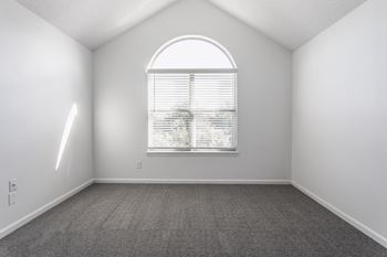 A room with a window and a carpeted floor